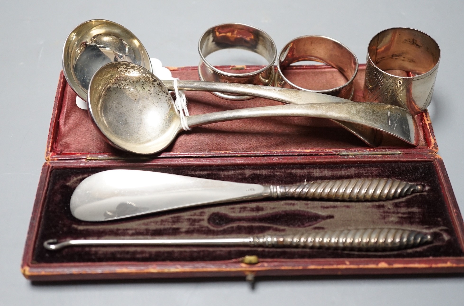 A pair of late Victorian silver Old English pattern sauce ladles, London, 1898, three silver napkin rings and a cased silver handled shoe horn and button hook.